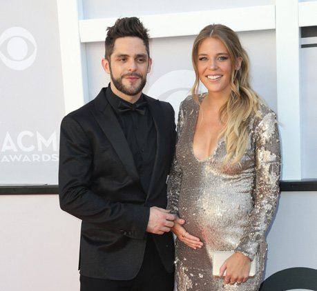 A couple posing on the red carpet at the 52nd ACM Awards