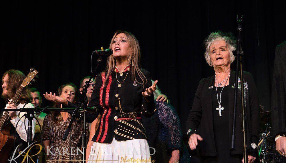 Brenda Best, Joanne Cash and other performers singing on stage at Songs For The Home Front